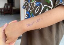 Dòng chữ nhắc “Nộp tiền học” được viết trên tay đứa trẻ gây tranh cãi