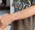 Dòng chữ nhắc “Nộp tiền học” được viết trên tay đứa trẻ gây tranh cãi
